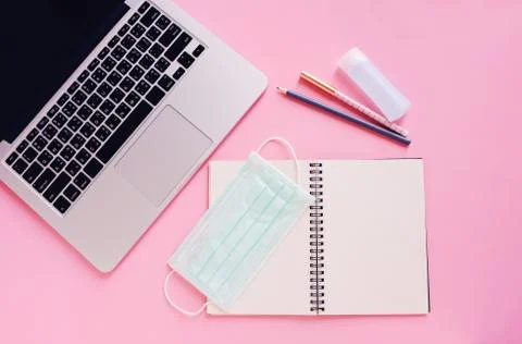 Top view flat lay of workspace desk with laptop, blank notebook, medical mask Foto stock