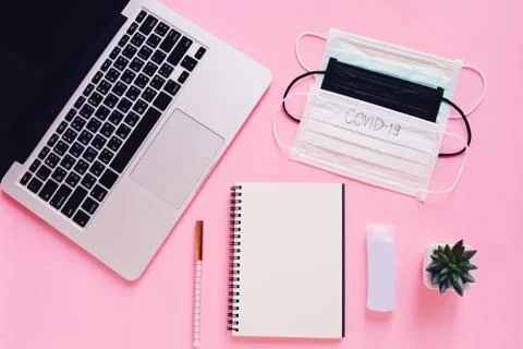 Top view flat lay of workspace desk with laptop, blank notebook, medical mask Foto stock