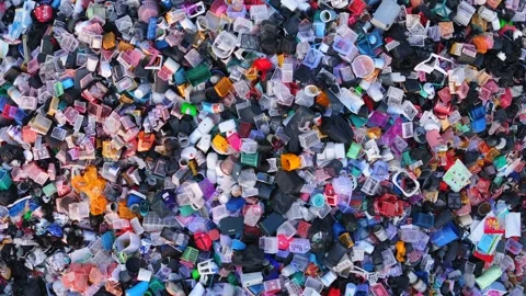 Top view flight above the pile of discarded plastic colorful containers and Stock Footage 314698632
