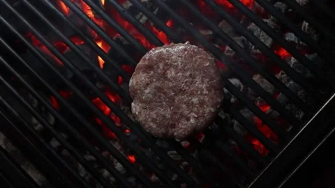 Top view of a flipping a beef-burger with a stainless spatula on a charcoal Vídeos de archivo 276805970