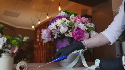Top view of florist hands making flower bouquet with decorative ribbon Stock Footage 76844830