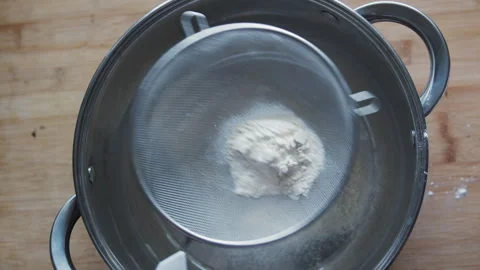 Top view of flour being sifted through a metal sieve. Stock Footage 331858079