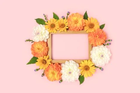 Top view of flower border frame made of dahlia, arnica and green leaves Stock Photos