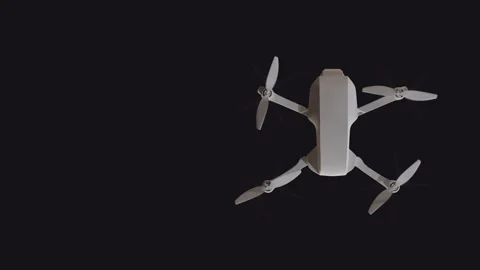 Top view of a flying drone with rotating propellers on a black background w.. Stock Footage 231705881