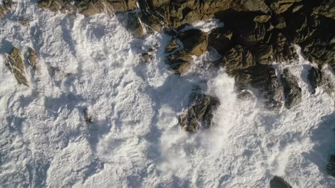 Top View Of Foamy Waves Breaking On The Rugged Shoreline. Aerial Shot Stock Footage 252831701