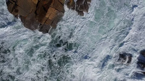 Top View Of Foamy Waves Breaking Onto Rocks Beach Stock Footage 325024715