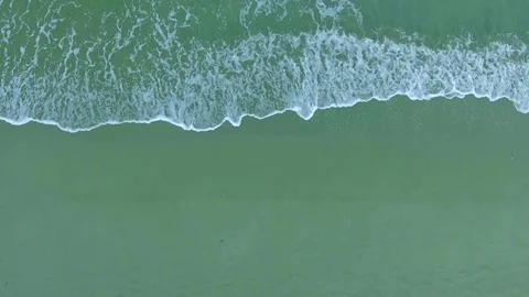 Top view foamy waves wash sandy beach aerial shot, shooting from helicopter Stock Footage 73529446