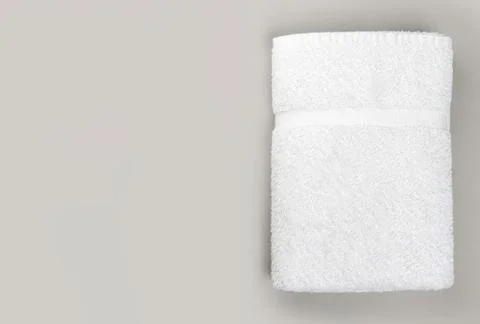 Top view of folded clean white bathroom towel on gray background with copy sp Stock Photos
