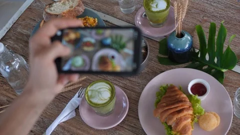 Top view food blogger taking pictures of breakfast in cafe. Womans hands take Stock Footage 257572995
