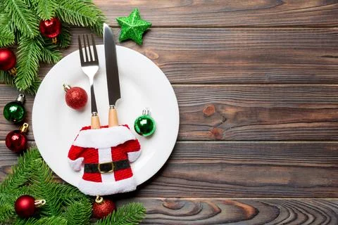 Top view of fork, knife and plate surrounded with fir tree and Christmas de.. Stock Photos