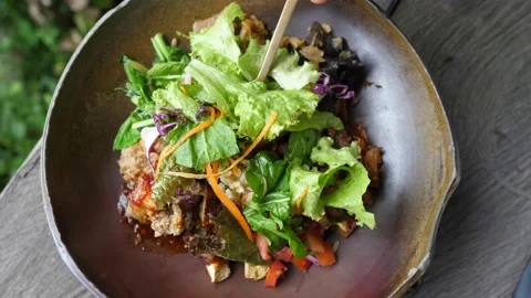 Top view of fork picking up a leaf from salad bowl and showing it to the camera Stock Footage 153458592