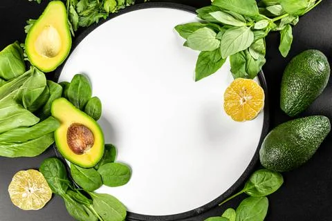 Top view, frame with green vegetables and herbs on black background Stock Photos