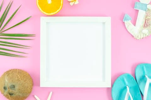 Top view frame on pink background with tropical leafs, coconut, orange and Stock Photos