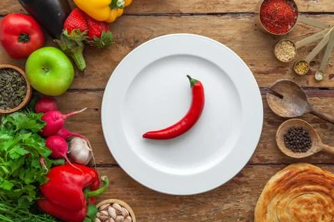 Top view of frame of various vegetables, herbs, oriental spices, white plate Stock Photos