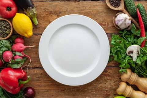 Top view of frame of various vegetables, herbs, oriental spices, white plate Stock Photos