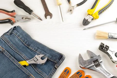 Top view, frame from work tools, glove and jeans on wooden background Stock Photos