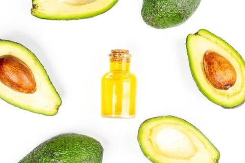 Top view of fresh avocado frame and bottle with oil on white background Stock Photos