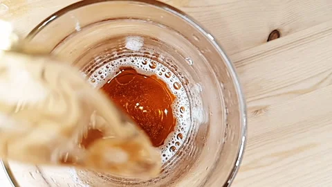 Top of view of  fresh beer with foam in front of wood background, beverage Video stock 260483663