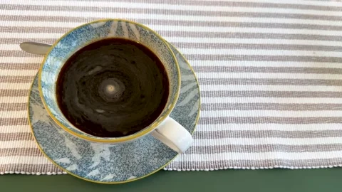 Top view of a fresh black coffee in a stylish blue and yellow ceramic cup on a Stock Footage 312468850