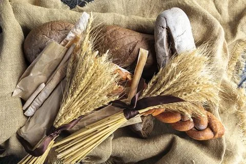 Top view of fresh bread and other baked goods in a basket lined with burlap and Stock Photos