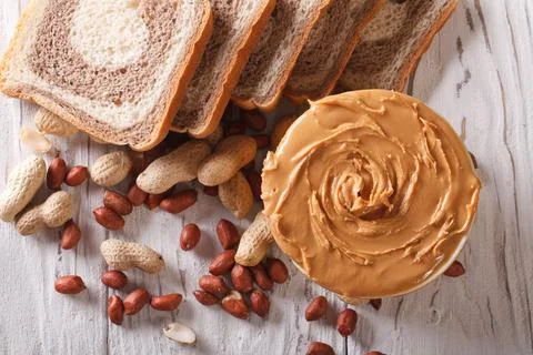 Top view of fresh bread slices with peanut butter and peanuts Stock Photos