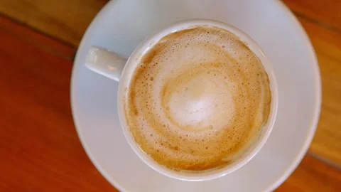 Top view of fresh cappuccino in white cup on wooden table. Stock Footage 337613952