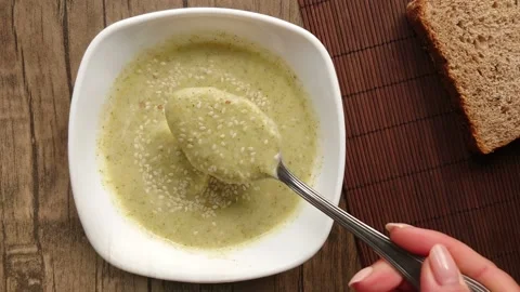Top view of fresh delicious broccoli cream soup with sesame seeds white bowl Stock Footage 233613738