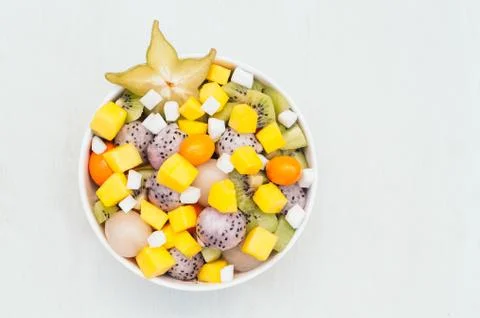 Top view of fresh exotic fruit in bowl. Pieces of white dragon fruit, kiwi, p Stock Photos