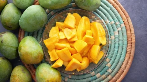 Top view of fresh green and sliced ripe mangoes on a dark background motion.. Stock Footage 332745241
