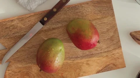 Top view of fresh mango on cutting board, orange and berries. Stock Footage 196629031