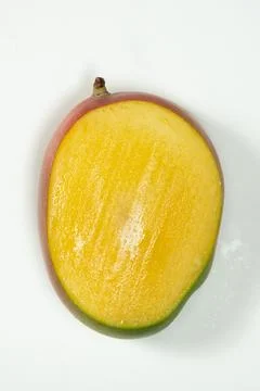 Top view of a fresh mango half with juicy yellow pulp. Stock Photos