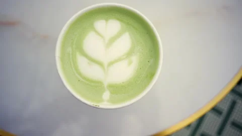 Top view of a fresh matcha latte with leaf pattern art in a takeaway cup si.. Stock Footage 336393641