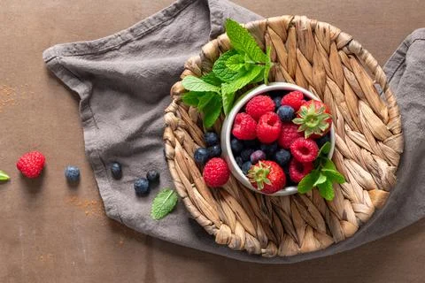 Top View of Fresh Mixed Berries in Bowl with Mint on Rustic Woven Tray Stock Photos