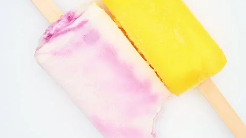 Top view fresh popsicles with some bites rotating on a white background Stock Footage 310413357