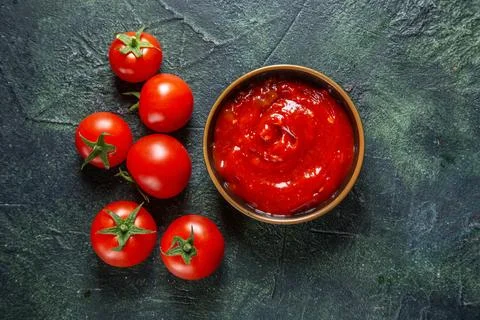 Top view fresh red tomatoes with tomato paste on dark background bread burg.. Stock Photos