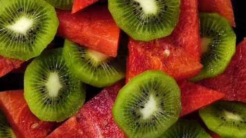 Top view of fresh red water melon in triangle pieces and sliced kiwi-fruit Stock Footage 76965898