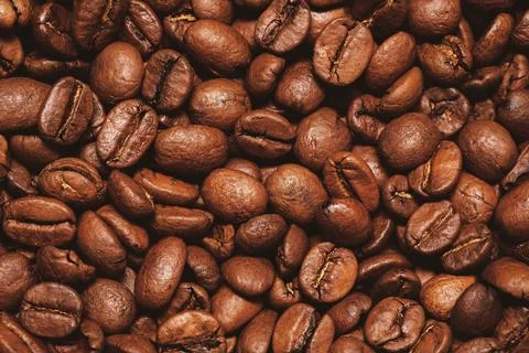 Top view of fresh roasted coffee beans background. Pile coffee texture beans. Stock Photos