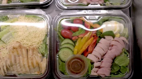 Top view of fresh salads packaged in clear plastic containers, featuring a Stockbeeldmateriaal 278017654