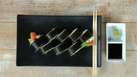 Top view of fresh sushi rolls on black plate, with chopsticks, soy Stock Footage 274475750