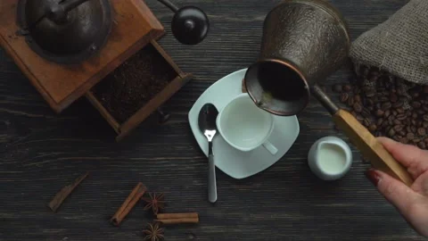 Top view of the fresh turkish coffee poured from copper jezva into the white cup Video stock 229268144