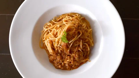 Top view of freshly cooked spaghetti bolognese on white plate on black table Stock Footage 127244869