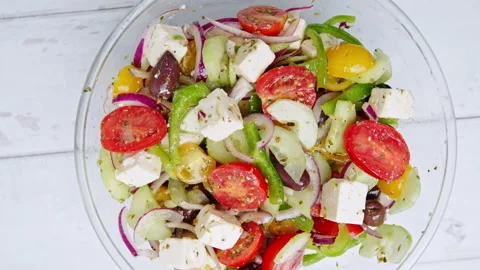 Top view of freshly made vibrant Greek Salad into a serving plate on the table. Stock Footage 142116860