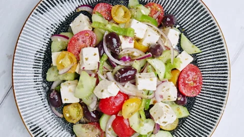 Top view of freshly made vibrant Greek Salad into a serving plate on the table. Stock Footage 142117662