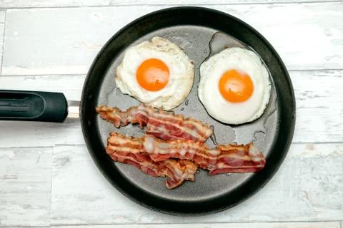 Top view of fried egg with bacon in a pan Stock Photos