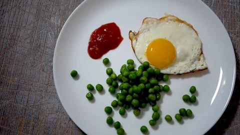 Top view of fried eggs eating with fork and knife. Traditional breakfast eggs ea Stock Footage 101024424
