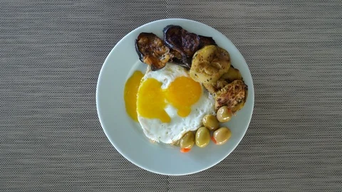 Top view, fried eggs with stewed vegetables and fresh olives. The plate rotat Video stock 119221529
