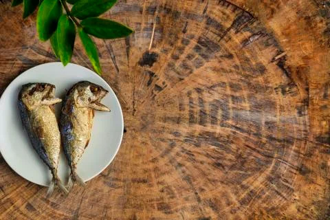 Top view fried mackerel on a white plate with real wooden table with copy spa Stock Photos