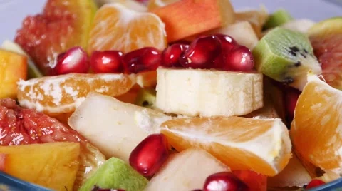 Top view of a fruit salad with mandarin, oranges, kiwi, pomegranate seeds, figs Stock Footage 68352386