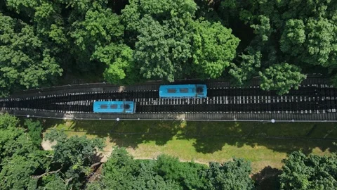 Top view of funiculars in a park area with tourists walking towards the station Stock Footage 156957916