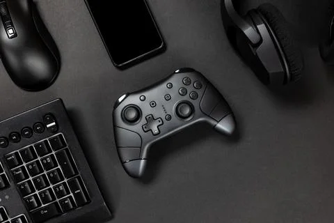Top view of game controller with gadgets and mobile phone on black gamer desk Stock Photos